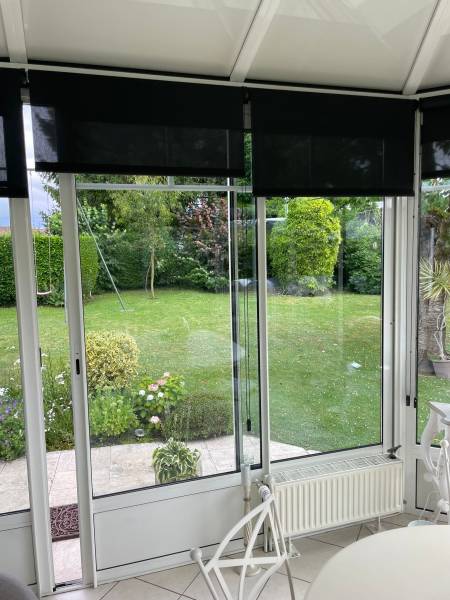 Véranda équipée de stores noirs Leroy Fermetures