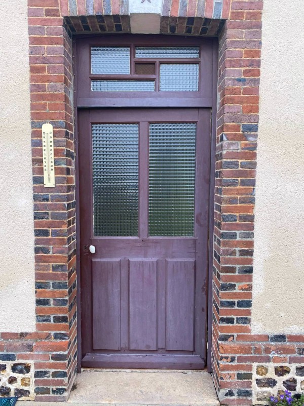 Porte d'entrée PVC Blanc teinté masse intérieure et plaxé chêne mat extérieur posé au alentour de la Barre en Ouche (27) par Leroy Fermetures