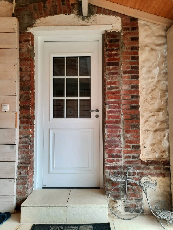 Jolie porte d'entrée Bel'm en aluminium pour cette belle maison normande posé par Leroy Fermetures du Neubourg.